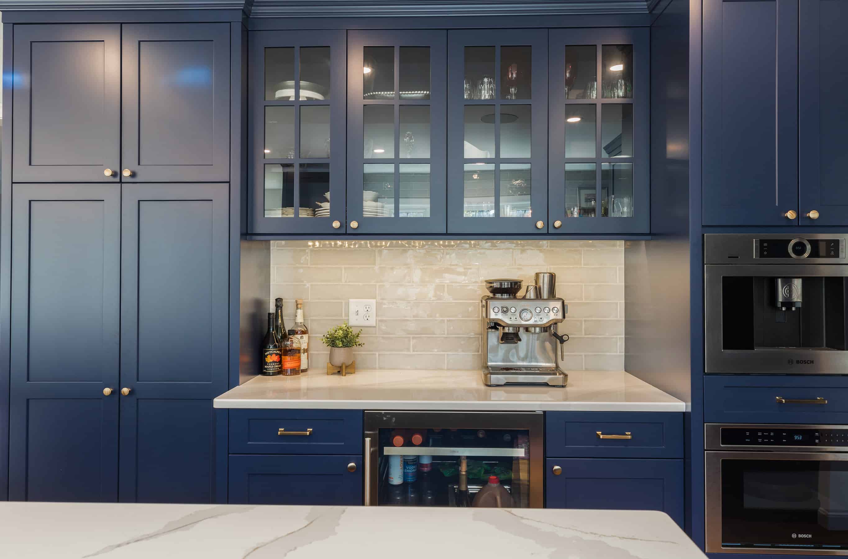 A custom beverage station in a kitchen featuring navy blue cabinetry. 