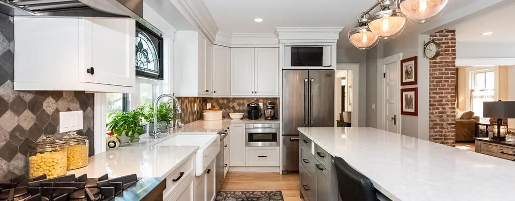 New England kitchen with large marble island and white cabinetry