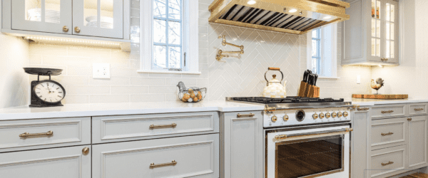French inspired kitchen with gold and white kitchen hood and oven