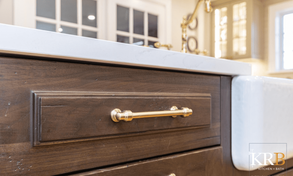 Close up gold hardware on dark wood cabinets