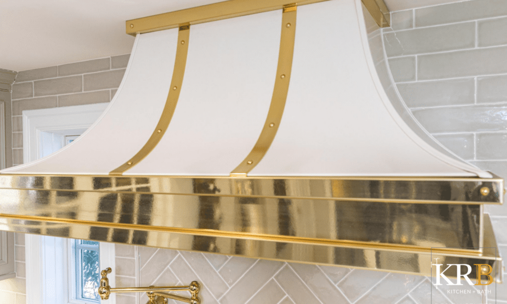 Close up of white kitchen hood with gold accents