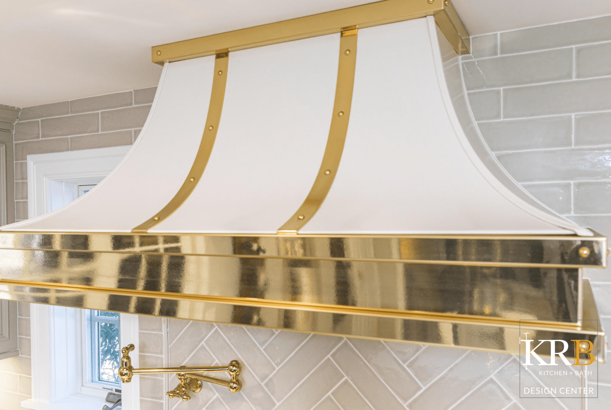 Close up of white kitchen hood with gold accents