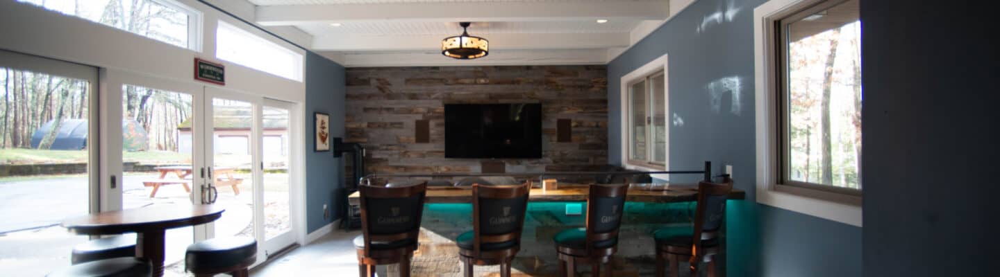 In home bar with wood accent wall and stone island