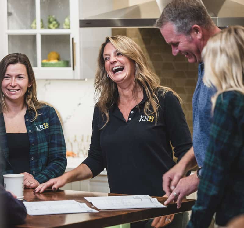 KRB Team members gathered around a table laughing brightly