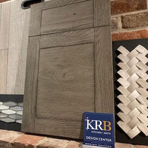 Gray wood cabinet sample with neutral tile samples