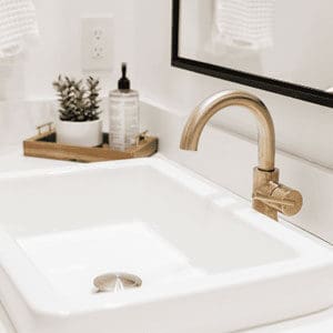 Close up bathroom sink with gold faucet